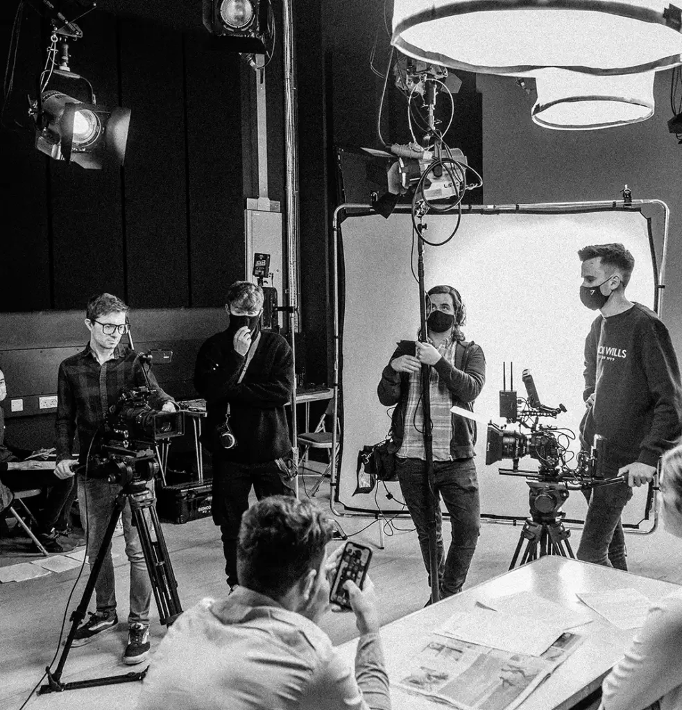 Equipo de producción audiovisual preparando un rodaje en estudio con cámaras e iluminación