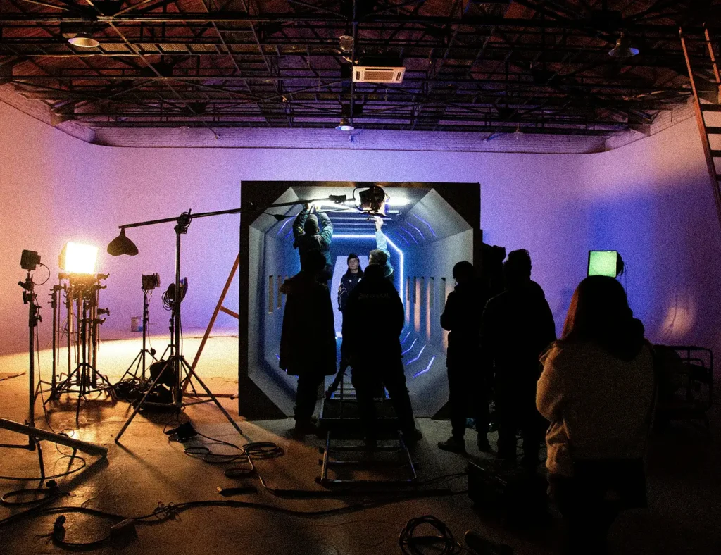 equipo de rodaje preparando iluminación y cámaras para grabar una escena en interior