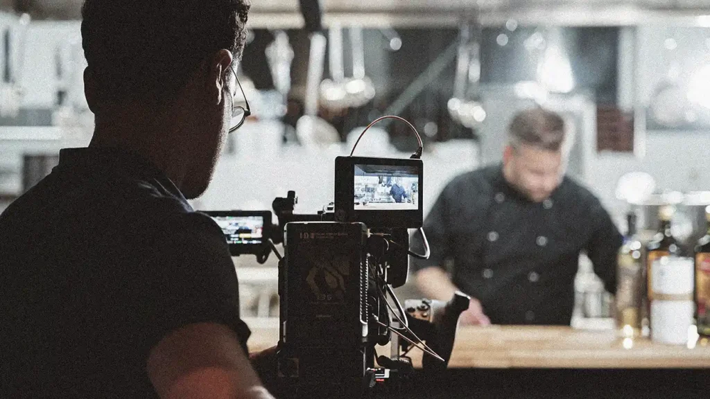 Equipo de rodaje grabando un spot publicitario en una cocina profesional